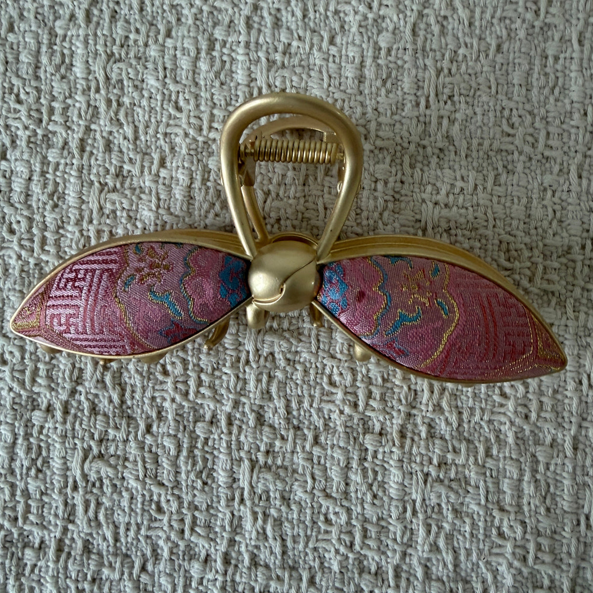 Pink Petal Bow Hair Claw Clip by JOFAE Kyoto. Petal-shaped bow loops; Pink patterned textile; Rounded gold-tone knot; Open-loop claw handle.