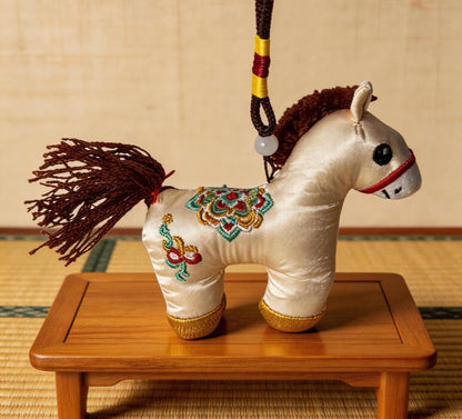 Hand-embroidered ivory Lucky Horse Charm by JOFAE Kyoto, a traditional Japanese amulet symbolizing protection and safe journeys.