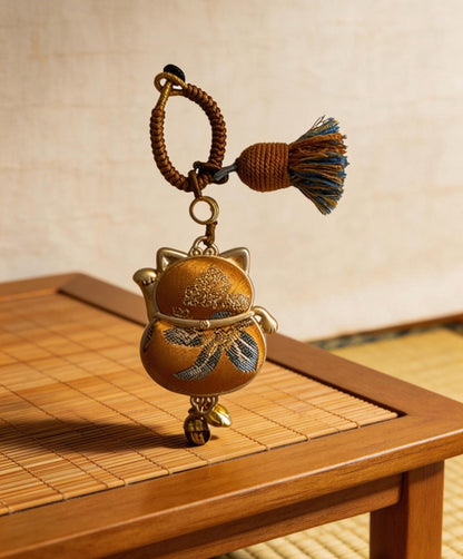 Yellow Maneki Neko lucky charm by JOFAE Kyoto, handmade cat amulet symbolizing wealth, success, and abundance.