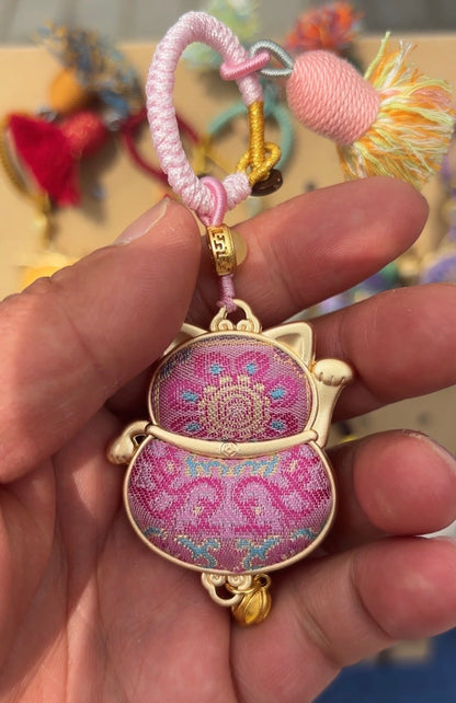 Pink Maneki Neko Lucky Charm handmade Kyoto amulet by JOFAE Kyoto, featuring a smiling cat figure with a gold coin and red collar.