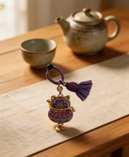 Purple Maneki Neko Lucky Charm by JOFAE Kyoto, handmade Japanese amulet symbolizing protection, wisdom, and inner balance.