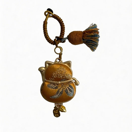 Yellow Maneki Neko lucky charm by JOFAE Kyoto, handmade amulet symbolizing wealth, success, and abundance in traditional craft style.