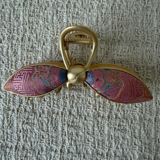Pink Petal Bow Hair Claw Clip by JOFAE Kyoto. Petal-shaped bow loops; Pink patterned textile; Rounded gold-tone knot; Open-loop claw handle.