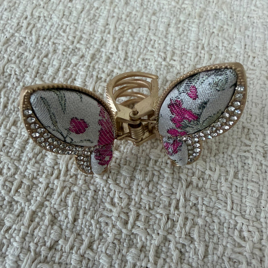 Ivory Floral Butterfly Hair Claw Clip by JOFAE Kyoto. Butterfly silhouette; Ivory textile with pink floral motifs; Clear sparkling wing accents; Gold-tone claw frame.